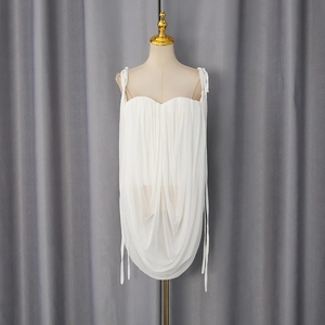 Detail of white pleated chiffon camisole with adjustable tie straps and flowy hemline