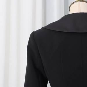 Detail of tailored black blazer collar and shoulder with premium matte fabric and stitching