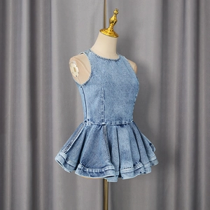 Detailed view of mid-blue washed denim vest with tiered peplum hem and round neckline