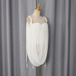 Detail of white chiffon camisole showing intricate pleated texture and soft draped fabric