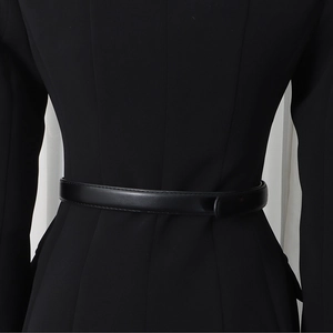 Detail view of the slim fit black blazer featuring a leather belt and tailored waist pleats