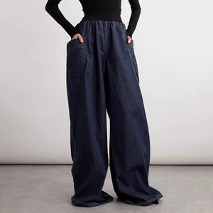 Detail view of high waist elastic waistband and large pockets on wide leg denim jeans
