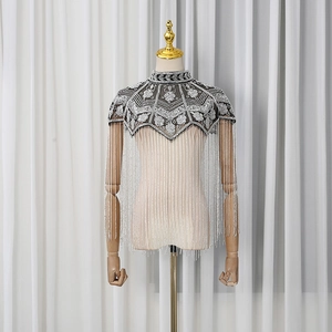 Detail of vintage beaded shawl featuring silver sequins and long tassel fringes on mesh