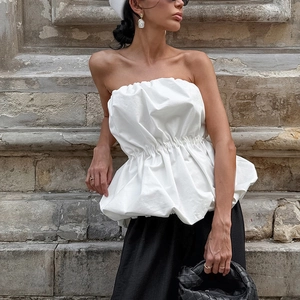 Détail d'un haut bustier blanc avec taille smockée et effet bouffant texturé en coton