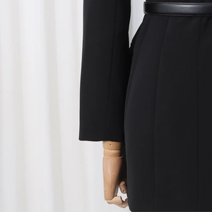 Detailed view of black slim-fit blazer waist featuring a sleek leather belt accessory