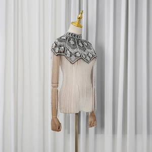 Detailed view of silver bead embroidery and long tassels on a black mesh floral shawl