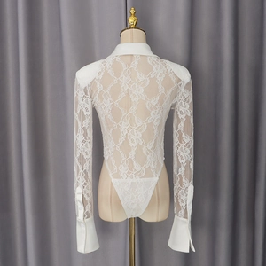 Macro shot of white lace bodysuit featuring intricate floral patterns and sleeve buttons