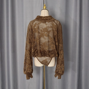 Détail d'un body en dentelle marron foncé avec manches bouffantes et motifs floraux