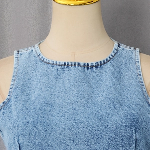 Detail of light blue denim vest showing the crew neck and premium stitching texture