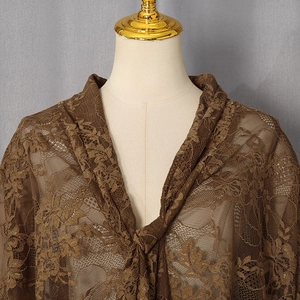 Détail d'un body en dentelle marron avec broderie florale et nœud à l'avant