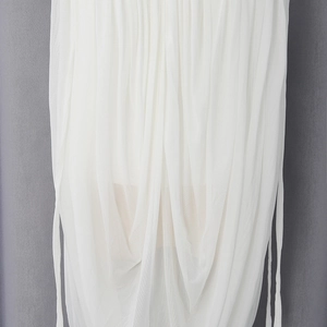 Detailed close-up of white mesh fabric with elegant pleated layers and side drawstring ties
