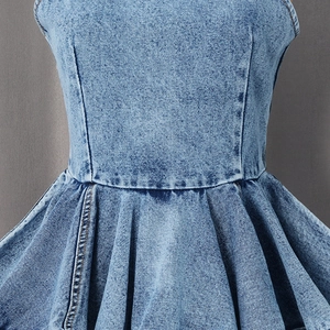 Detailed view of light blue denim fabric with waist pleats and precise stitching lines