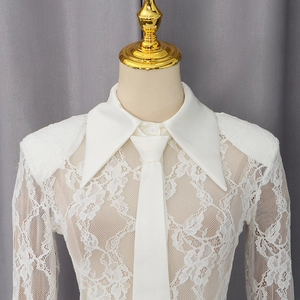 Detailed view of white floral lace shirt with elegant narrow tie and pointed collar