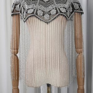 Close-up of vintage sequined flower patterns and silver beaded fringe on black mesh shawl