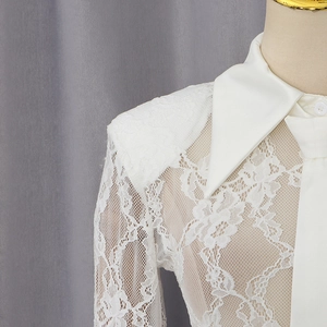Detailed close-up of white lace sleeves and floral patterns on women's bodysuit