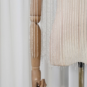 Detail shot of silver sequin and beaded fringe tassels on a designer fashion shawl