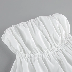 Détail d'un haut bustier blanc montrant la texture froncée du tissu et la qualité couture