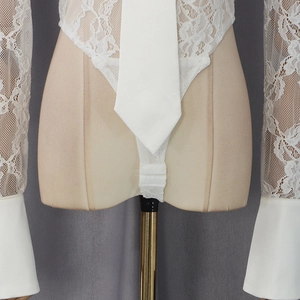 Detail of white lace long sleeve bodysuit with neck tie and crochet texture