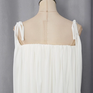 Detail of white pleated camisole showing vertical texture and adjustable shoulder straps