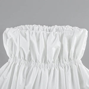 Gros plan d'un haut bustier blanc avec des smocks élastiques et des bords volantés