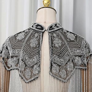Close-up of silver beadwork and sequins on black mesh shawl with tassel fringe