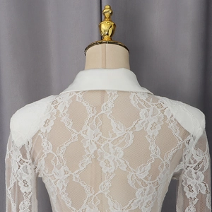 Detail of white lace long sleeve bodysuit showing floral texture and padded shoulders