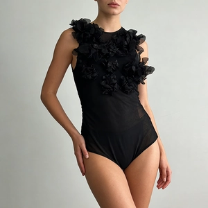 Detail of black mesh bodysuit featuring exquisite 3D floral appliques and sheer texture