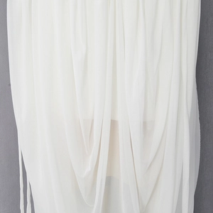 Close-up of white semi-transparent mesh fabric with elegant pleated texture and soft drape