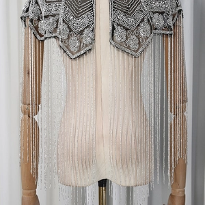Detailed view of silver hand-beaded flower shawl with long cascading fringe tassels