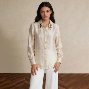 Detail of satin shirt collar featuring dark crystal embellishments and pearl buttons