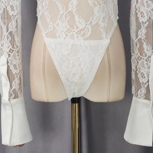 Detail of white floral lace bodysuit featuring elegant satin cuffs with white buttons