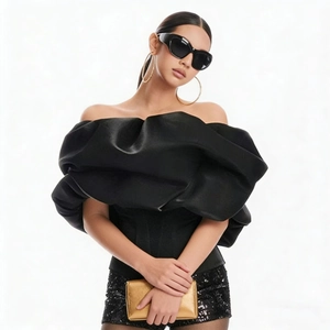 Close-up of black off-the-shoulder corset top with voluminous ruffled neckline detail