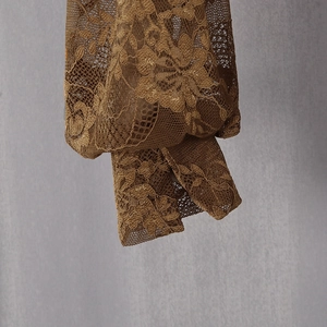 Détail de la manche en dentelle marron avec broderie florale et fente élégante au poignet