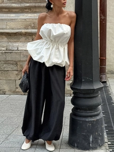 Haut blanc sans bretelles élégant associé à un pantalon large noir sur un mannequin