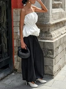 Haut bustier blanc chic à volants avec un pantalon noir élégant à jambes larges
