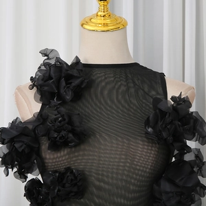 Detail of black sheer mesh bodysuit with 3D floral appliques on shoulder and chest