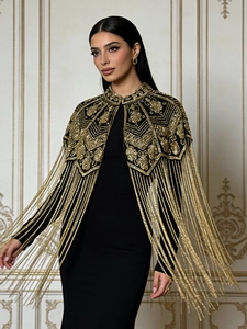 Elegant black shawl with gold floral sequins and long tassels over a sleek evening dress