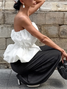 Top bustier blanc à volants et pantalon large noir pour un look de printemps élégant