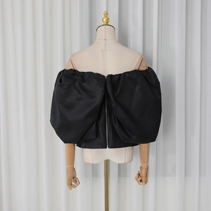Detail of black off-shoulder corset top featuring puff sleeves and silver back zipper