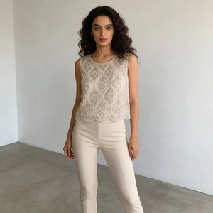 Détail du gilet brodé champagne avec paillettes et ourlet festonné sur une tenue