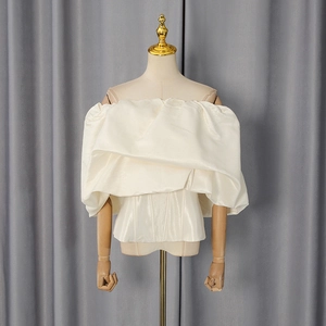 Detail of off-white off-the-shoulder top with ruffled satin bubble sleeves and corset waist