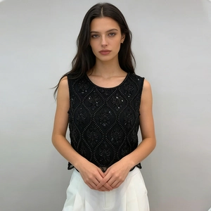 Détails de broderie de perles noires et motifs de paillettes sur un haut sans manches