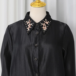 Detailed view of black satin shirt collar featuring exquisite rhinestone and sequin petals