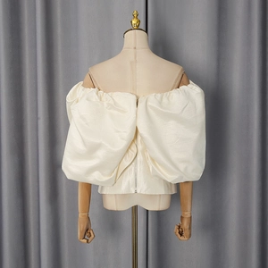 Back view of cream off-shoulder top with voluminous puff sleeves and metal zipper