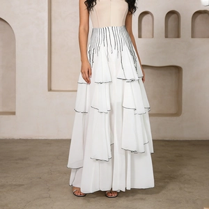 Detail of layered white mesh skirt with delicate black trim and high waist design