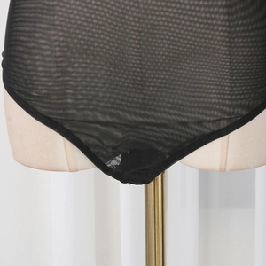 Close-up of black mesh bodysuit showing elastic sheer fabric and fine edging details