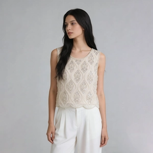 Détail de la broderie de perles lourdes et de l'ourlet festonné du haut sans manches