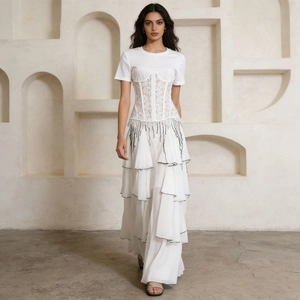 Detail of white lace corset layered over a T-shirt with tiered ruffle skirt