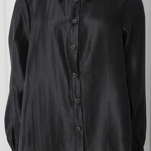 Detailed close-up of glossy black satin fabric texture and elegant buttons on the sleeve