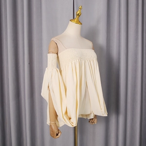 Detail of smocked chest texture and voluminous puff sleeves on beige tube top